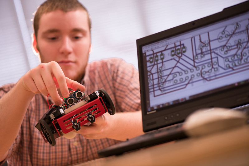 Picture of student working on a robot for electrical engineer class.